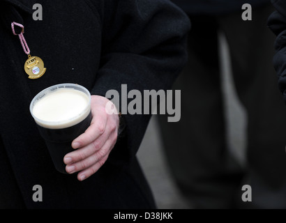 Ein Mann trinkt einen Pint Guinness am St. Patricks Day während des Cheltenham-Pferderennen-festival Stockfoto