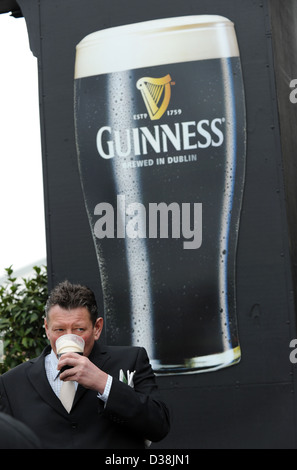 Ein Mann trinkt einen Pint Guinness am St. Patricks Day während des Cheltenham-Pferderennen-festival Stockfoto