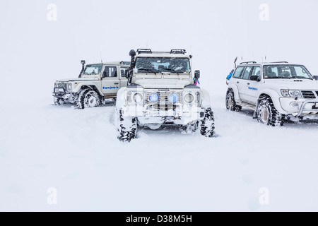 Snowy Land Rover Defender 4v4 4WD Fahrzeuge in schweren Schnee gefroren Bedingungen auf einem Touristen Sightseeing Abenteuer Ausflug in Island im Winter Stockfoto