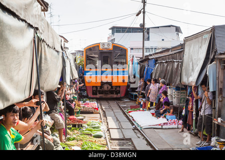 Trainieren im Maeklong Railway Station und Markt, Thailand, Marktfahrer heben Markisen ermöglichen Schulen übergeben Stockfoto