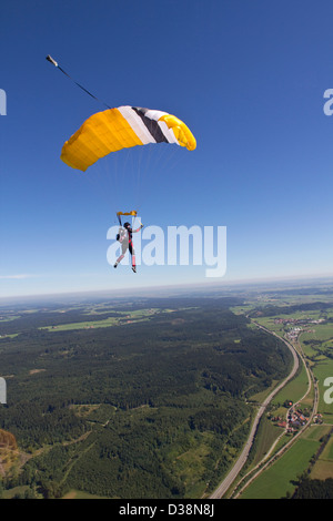 Frau Fallschirmspringen über ländliche Landschaft Stockfoto