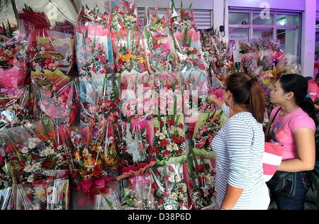 Eine Frau prüft Sträuße zum Verkauf vor Valentinstag auf dem Dangwa Markt in Manila, Philippinen, Mittwoch, 13. Februar 2013. Am 14. Februar ist Valentinstag beobachtet eine oder mehrere frühen christlichen Märtyrer, die Heiligen Valentin benannt zu Ehren. Es war der erste von Papst Gelasius ich 496 n. Chr. gegründet und wurde später von allgemeiner Römischer Kalender der Heiligen im Jahr 1969 von Papst Paul VI gelöscht. Stockfoto