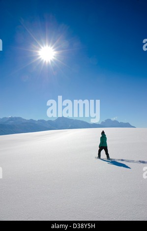 Single-Frau mit Schneeschuhen auf einem Spaziergang im frischen Pulverschnee in Bayern, Deutschland Stockfoto