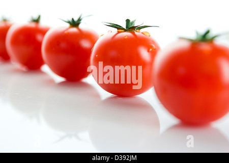 Linie von nassen, Cherry-Tomaten auf weißem Hintergrund Stockfoto