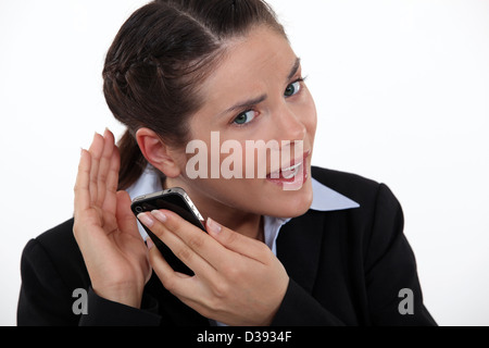 Frau, die kämpfen, um das Telefon zu hören Stockfoto