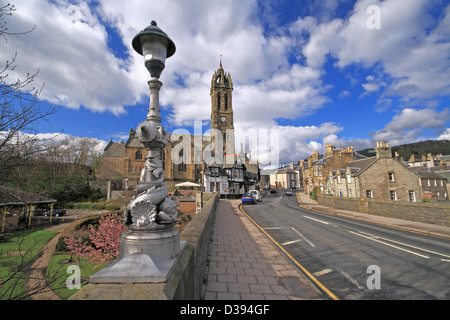 Straßenbrücke über den Fluss Tweed in Peebles, Grenzen, Schottland mit der alten Pfarrkirche Stockfoto