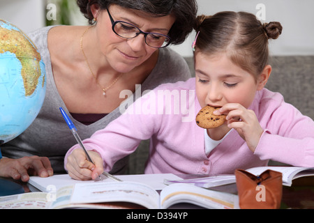 Frau, die ihre Enkelin bei ihren Hausaufgaben helfen Stockfoto
