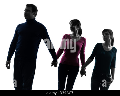 eine Familie Vater Mutter Tochter Mann geht Hand in Hand in Silhouette Studio isoliert auf weißem Hintergrund Stockfoto