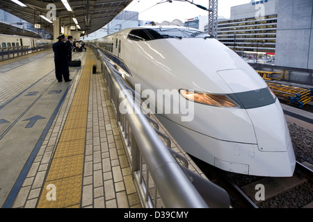 Schlanke, weiße Japan Railways Super-express Shinkansen-Hochgeschwindigkeitszug am Bahnsteig im Bahnhof Tokio erwartet. Stockfoto