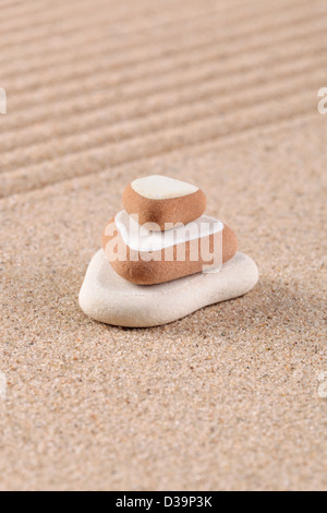 Drei Steinen gestapelt auf einem geharkt Sand Zen-Garten. Stockfoto