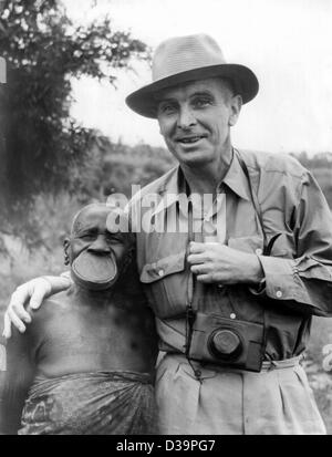 (Dpa-Dateien) - zeigt ein undatiertes Datei Bild Arzt Bernhard Grzimek, Direktor des Frankfurter Zoos, in Afrika, als er mit einer einheimischen stellt deren Mund durch einen Dübel vergrößert wird. Stockfoto