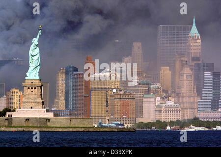 (Dpa) - die Statue of Liberty Gesichter die Rauch-begraben Skyline von Manhattan Recht, nachdem die Zwillingstürme des World Trade Center in New York City zusammengebrochen, 11.9.2001. Die WTC Wolkenkratzer zusammengebrochen nach Selbstmord-Anschläge von islamistischen Terroristen mit entführten Flugzeugen begrub Tausende Opfer unter den Stockfoto