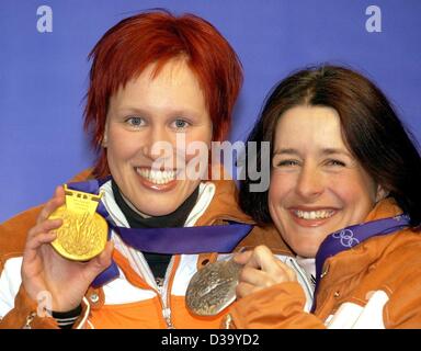 (Dpa) - XIX Olympische Winterspiele: Kati Wilhelm (l) zeigt ihre Goldmedaille ihre Teamkollegin Uschi Disl ihre Silbermedaille nach der Preisverleihung in Salt Lake City, 13.2.2002. Sie gewannen die 7,5 km Biathlon. Stockfoto