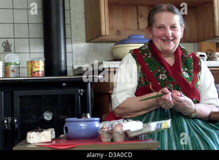 (Dpa) - eine ältere Frau, gekleidet in traditioneller Tracht der Region, ist bemalen von Ostereiern in der Küche ihres Hauses in Erfurtshausen in der Nähe von Marburg, Deutschland, 27. März 2002. Die spezifischen Tradition der Malerei der Ostereier hat seine Wurzeln im 18. Jahrhundert. Stockfoto