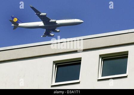 (Dpa) - eine Lufthansa-Flugzeug fliegt in geringer Höhe über ein Appartment-Haus in der Nähe von Frankfurt, 3. April 2002, Richtung Land am Rhein-Main-Flughafen. Die Bedrängnis durch Flugzeuge Geräusche ist ein großes Problem in der Nähe von Frankfurt, Deutschlands größtem Flughafen. Stockfoto