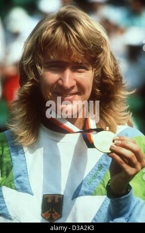 (Dpa-Dateien) - mit einem glücklichen Lächeln deutscher Tennis Spieler Steffi Graf präsentiert ihre Goldmedaille sie bei den Frauen gewann-Finale der Olympischen Sommerspiele in Seoul, 1. Oktober 1988. Sie hatte geschlagen die argentinischen Spieler Gabriela Sabatini 6:3, 6:3. Stockfoto