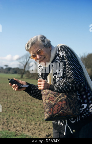 Ältere Frau mit ihrem Mobiltelefon auf dem Lande gejagt von einem mugger Stockfoto