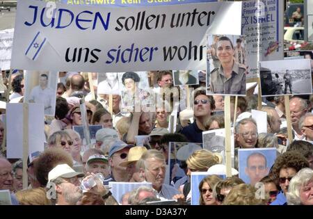 (Dpa) - Demonstranten halten Banner, die "Juden sind bei uns sicher Leben" zu lesen und Bilder von Verwandten, die bei Angriffen, während einer Demonstration gegen Terror und Antisemitismus in München, 12. Juli 2002 gestorben. Stockfoto