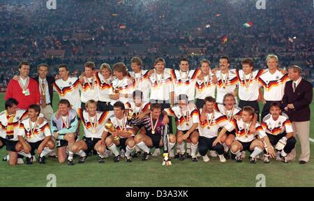 (Dpa-Dateien) - stellen die deutsche Mannschaft mit ihren Medaillen und Trophäen gewann das Endspiel der Fußball-WM in Rom, Italien, 8. Juli 1990. Das Team des damaligen deutschen National Trainer Franz Beckenbauer (2. v. L, hintere Reihe) und sein Nachfolger Berti Vogts (R, hintere Reihe) besiegte Argentinien 1:0. Stockfoto
