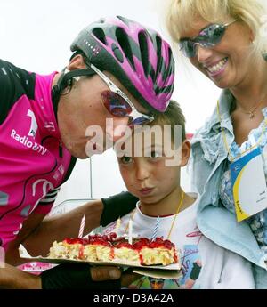 (Dpa) - deutsche Läufer Erik Zabel Telekom Team (L) und sein Sohn Rick (C) bläst die Kerzen die Geburtstagstorte als seine Frau Cordula lächelt und schaut vor die erste Etappe der Tour De France in Luxemburg, 7. Juli 2002. Stockfoto