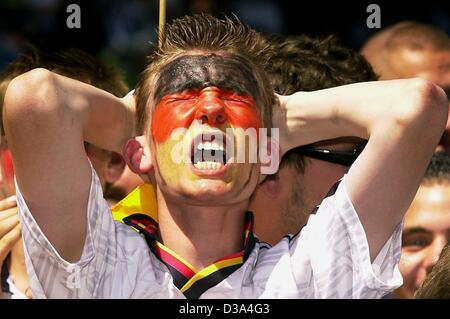 (Dpa) - ein Verfechter der deutschen Fußball-team mit deutscher Flagge gemalt in seinem Gesicht schreit frustriert, als er im Finale auf einem Bildschirm in München, 30. Juni 2002 Uhren. Brasilien spielt Deutschland 2:0 in der FIFA World Cup Finale in Yokohama, Japan, ein Rekord, fünf Mal Weltmeister. Stockfoto