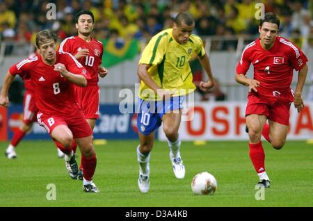 (Dpa) - der brasilianische Mittelfeldspieler Rivaldo (C) von türkischen Spieler Tugay Fazackerley (L), Yildiray Bastuerk und Fatih Akyel (R), während das Halbfinale im Stadion von Saitama, Japan, 26. Juni 2002 gejagt wird. Das Spiel endete 1:0 für Brasilien, das zum 7. Mal für das WM-Finale qualifiziert. Stockfoto