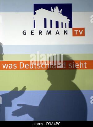 (Dpa) - die Silhouette der beiden Journalisten anschlagen ist das Logo der "Deutschen TV" in Berlin, 1. März 2002. German TV ist ein Projekt der öffentlich-rechtlichen Sender ARD, ZDF und Deutsche Welle und wird als Pay-TV in den USA angeboten werden. Die gemeinsame Kanal Aimes in einem Deutsch sprechenden Publikum in den USA und ist erwartete t Stockfoto