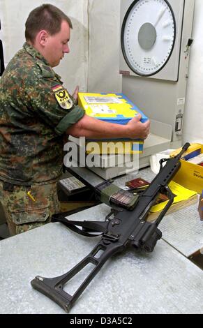 (Dpa) - ein deutscher Soldat von der International Assistance (ISAF) wiegt ein Paket in der Postfiliale im Militärlager in der Nähe von Kabul, Afghanistan, 29. März 2002. Mail-Wise gilt das ISAF-Camp als deutschem Boden, so dass Buchstaben und Pacels mit deutschen Briefmarken abgeschickt werden kann. Rund Stockfoto