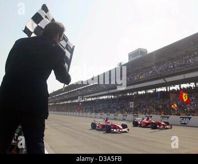 (Dpa) - Michael Schumacher (R), deutscher Formel 1 Pilot (Ferrari) und sein brasilianischer Teamkollege Rubens Barrichello kommen auf der Ziellinie von den großen Preis der USA auf dem Motor Speedway in Indianapolis, USA, 29. September 2002. Das Duo feierte ihre achte doppelten-Sieg in dieser Saison, mit Stockfoto