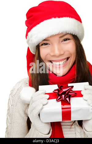 Freudige Mischlinge asiatischen kaukasischen Frau trägt Weihnachtsmütze zeigt Weihnachtsgeschenk isoliert auf weißem Hintergrund Stockfoto