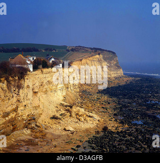 Häuser auf Klippe durch Erosion. Fairlight Cove, East Sussex, UK. (1980) Stockfoto