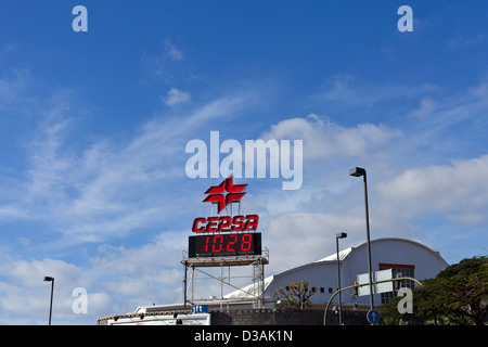 CEPSA Leuchtreklame und Digital clock in rot vor blauem Himmel mit helle Wolke in Santa Cruz De Tenerife, Kanarische Inseln, Spanien. Stockfoto