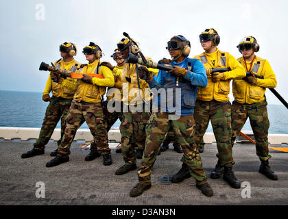 US Navy Feuer Schlauch-Teams stehen während einer simulierten Flugzeug Absturz mass Casualty Drill an Bord der amphibischen Angriff Schiff USS Bonhomme Richard 13. Februar 2013 in den Golf von Thailand. Die Bonhomme Richard amphibische bereit Group beteiligt sich an Gold Cobra, eine Thai-US-gemeinsame Übung. Stockfoto