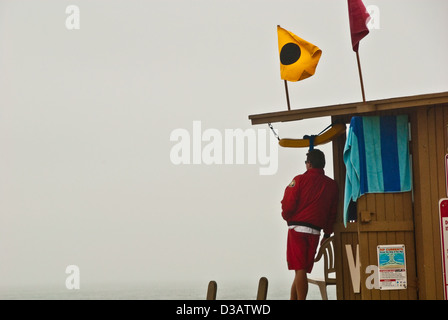 Rettungsschwimmer auf der Keil in Newport Beach an einem nebligen Morgen California. Blackball Flagge zeigt nur Bodysurfen. Stockfoto