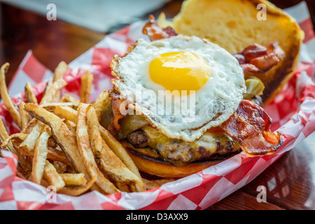 Korb mit Pommes Frites mit Cheeseburger und Ei Stockfoto