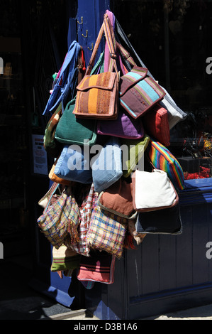 Schulter-Taschen zum Verkauf, hängen vor einem Geschäft in Whitby, North Yorkshire, England, UK Stockfoto