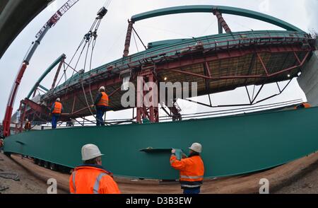 Arbeiter mithilfe ein Krans zwei 38-Tonne wiegen stehlen Strahlen auf der Baustelle Deutschlands längste Eisenbahnbrücke in der Nähe von Halle, Deutschland, 15. Februar 2013 zusammenstellen. Nach dem Bau der 8,5 Kilometer langen Saale-Elster-Brücke müssen Tracks und Bahntechnik installiert werden. ICE-Züge sollen im Jahr 2015 300 Kilometer pro Stunde zwischen Nürnberg, Erfurt/Halle/Leipzig und Berlin zu erreichen. Foto: Hendrik Schmidt Stockfoto