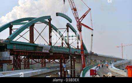 Arbeiter mithilfe ein Krans zwei 38-Tonne wiegen stehlen Strahlen auf der Baustelle Deutschlands längste Eisenbahnbrücke in der Nähe von Halle, Deutschland, 15. Februar 2013 zusammenstellen. Nach dem Bau der 8,5 Kilometer langen Saale-Elster-Brücke müssen Tracks und Bahntechnik installiert werden. ICE-Züge sollen im Jahr 2015 300 Kilometer pro Stunde zwischen Nürnberg, Erfurt/Halle/Leipzig und Berlin zu erreichen. Foto: Hendrik Schmidt Stockfoto