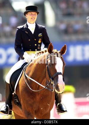 (Dpa) - deutsche Fahrer Nadine Capellmann mit ihrem Pferd "Farbenfroh" (bunte) während der Dressur-Veranstaltung bei den Weltreiterspielen in Jerez, Spanien, 13. September 2002 führt. Stockfoto