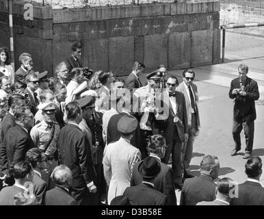 (Dpa-Dateien) - US-Präsident John F. Kennedy ist umgeben von Journalisten, wie er Checkpoint Charlie an der Berliner Mauer in West Berlin, 26. Juni 1963 übergibt. Der Höhepunkt des seinen sieben-Stunden-Aufenthalt in Berlin war seine Rede, in denen drückte er seine Gefühle für die geteilte Stadt mit den Worten auf Deutsch "Ich bin Stockfoto