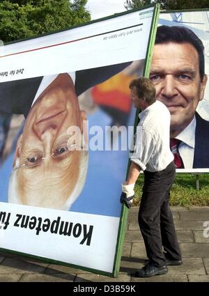 (Dpa) - ein Arbeiter der Wahlplakate entfernt einen Tag nach den Parlamentswahlen, Hamburg, 23. September 2002. Das Plakat zeigt Kandidaten Edmund Stoiber ist entfernte Kopf zuerst, während Bundeskanzler Gerhard Plakat noch im Hintergrund steht. Schroeders Sozialdemokratische Partei SPD gewann Stockfoto