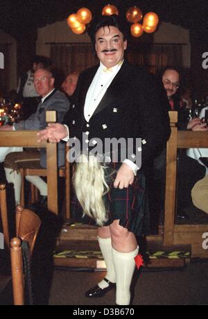 (Dpa-Dateien) - Rudolph Moshammer, exzentrische deutscher Modedesigner, trägt einen schottischen Kilt und Strümpfe an Filserball, eine Karnevalsparty in München, 26. Februar 2000. Nach einer Lehre in einem Textilunternehmen begann Moshammer seine Karriere bei Christian Dior in Paris. 1967 eröffnete er zusammen Stockfoto