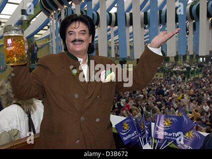 (Dpa-Dateien) - Rudolph Moshammer, exzentrische deutscher Modedesigner, stellt mit einem Bier, wie er auf dem Oktoberfest in München, 17. September 2000 Parteien. Nach einer Lehre in einem Textilunternehmen begann Moshammer seine Karriere bei Christian Dior in Paris. 1967 eröffnete er, zusammen mit seiner Mutter, seiner Stockfoto