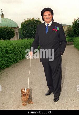 (Dpa-Dateien) - Rudolph Moshammer, exzentrische deutsche Modedesignerin, führt ein Spaziergang mit seinem Terrier Dame namens Daisy im Hofgarten in München, 16. Juni 1999. Nach einer Lehre in einem Textilunternehmen begann Moshammer seine Karriere bei Christian Dior in Paris. 1967 eröffnete er zusammen mit seinem mo Stockfoto