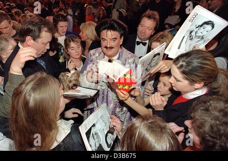 (Dpa-Dateien) - Rudolph Moshammer, exzentrische deutscher Modedesigner, Autogramme für die Fans nach einer Charity Circus Show im Münchner Circus Krone, 2. Dezember 2000. Stockfoto