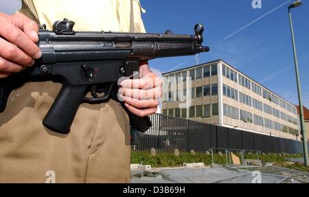 (Dpa) - ein Polizist hält eine Maschinengewehr steht er vor dem amerikanischen Konsulat in München, 4. September 2002. Der bayerische Innenminister Guenther Beckstein hielt eine Pressekonferenz über die Situation der Sicherheit in Bayern und eine erhöhte abstrakte Gefahr gewarnt. Es gibt keine Stockfoto