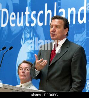 (Dpa) - Bundeskanzler Gerhard Schroeder spricht, steht er vor der Schrift 'Deutschland' während einer Parteikonferenz in Berlin, 18. August 2002. Im Hintergrund Franz Muentefering, Generalsekretär der deutschen Sozialdemokratischen Partei (SPD). In seiner Rede unterstützt Schröder die Hartz Stockfoto