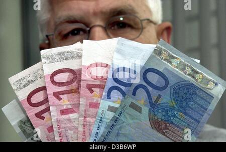 (Dpa) - hält Polizist Jürgen-Peter Schmidt echten Euro-Banknoten, die aussehen wie Falschgeld, in Hamburg, 8. August 2002. Wenn in der Waschmaschine gewaschen, der 20 Euro-Schein verfärbt und das Papier wird ganz blau, und der Hologramm-Streifen wird zerfetzten. Stockfoto