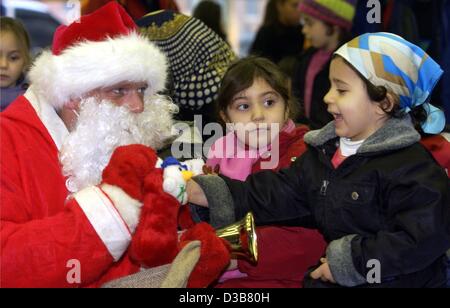 (Dpa) - ein kleines Mädchen erhält Süßigkeiten von Sankt Nikolaus (St. Nikolaus) in Berlin, 6. Dezember 2002. Als eine deutsche Tradition ist 6. Dezember der Festtag des Heiligen Nikolaus, der gibt Süßigkeiten und kleine Leckereien für Kinder nach der Feststellung, wer schön brav gewesen war. Stockfoto