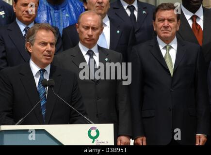 Der britische Premierminister Tony Blair (vorne) macht eine Aussage vor das Familienbild des G8-Gipfels auf der hoteleigenen Terrasse in Gleneagles, Schottland, Freitag, 8. Juli 2005. Das Bild zeigt im Hintergrund italienischen Ministerpräsidenten Silvio Berlusconi, der russische Präsident Vladimir Putin und deutschen Cha Stockfoto